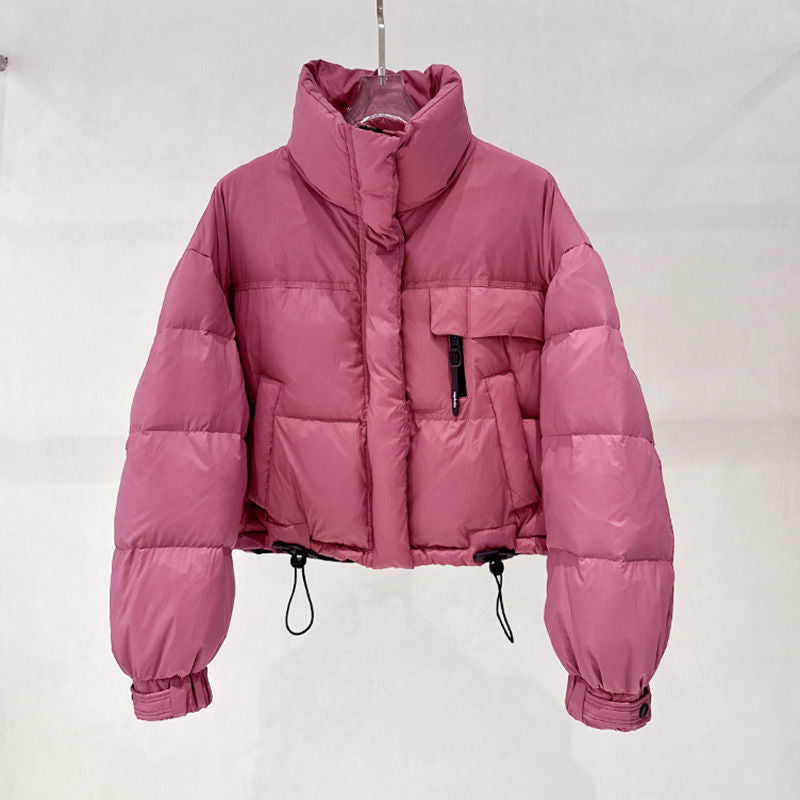 Pink cropped puffer jacket with high collar, zippered chest pocket, and adjustable hem cords