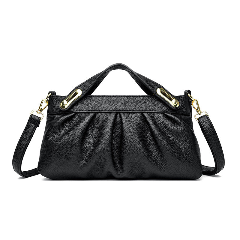 Black leather handbag with gold hardware, detachable shoulder strap, and gathered front design