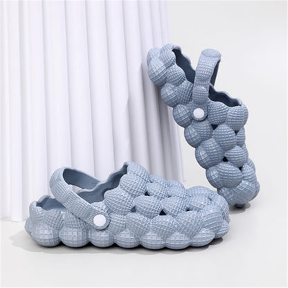 Light blue bubble-textured slip-on clogs with adjustable back strap on white surface