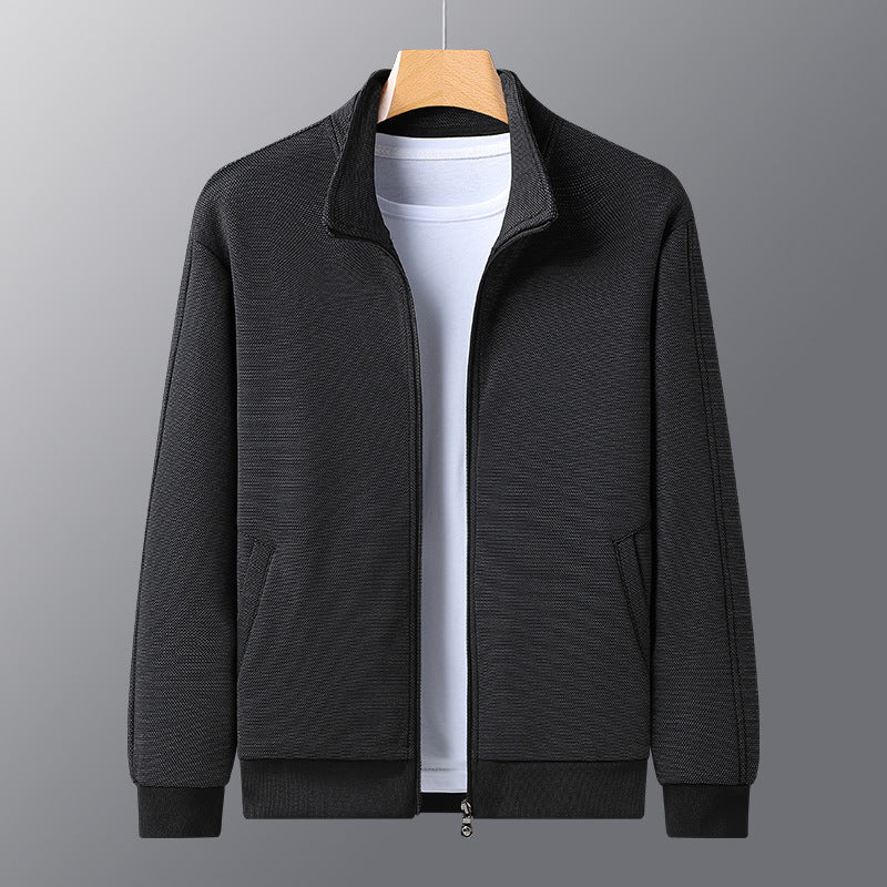 Black textured zip-up jacket on hanger over white t-shirt on gray background