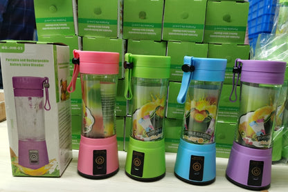 Row of pink, green, blue, and purple portable rechargeable battery juice blenders with green product boxes in background