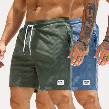 Men wearing casual corduroy shorts in green and blue with white drawstrings and patch logos