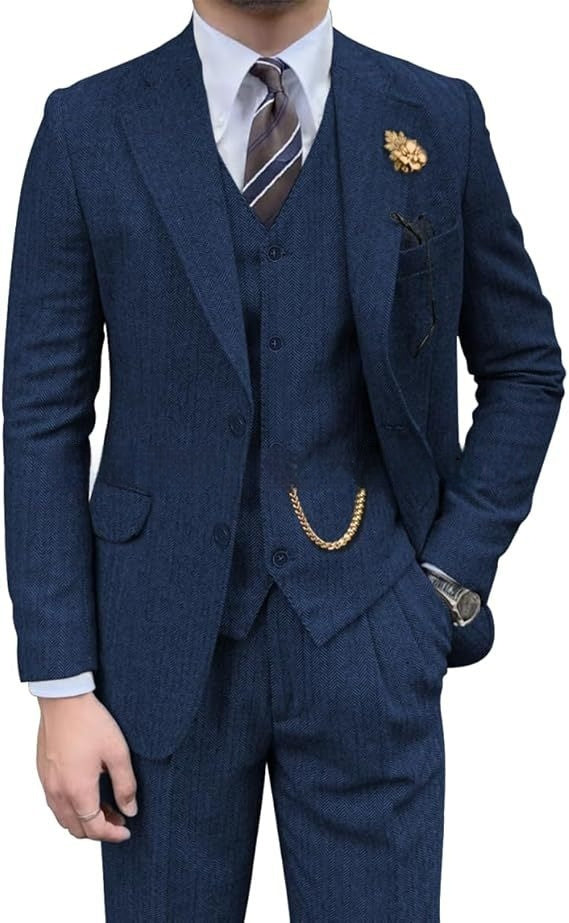 Man wearing a tailored blue herringbone three-piece suit with striped tie and gold chain accessory