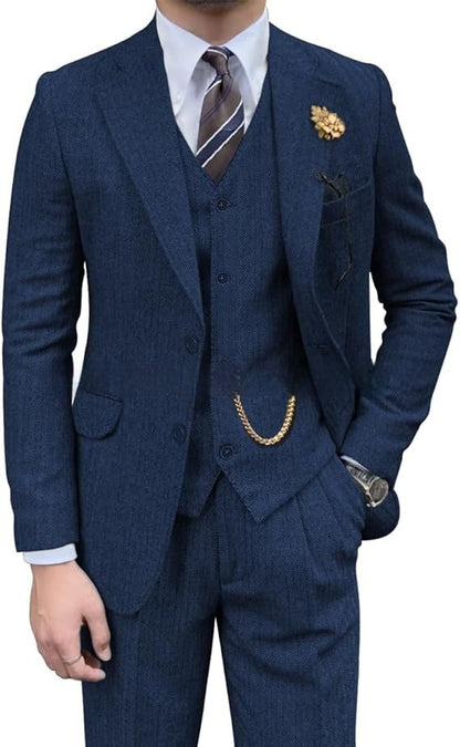Man wearing a tailored blue herringbone three-piece suit with striped tie and gold chain accessory