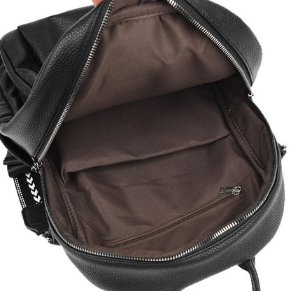 Open black leather backpack showing spacious brown fabric interior with zippered pocket and adjustable straps