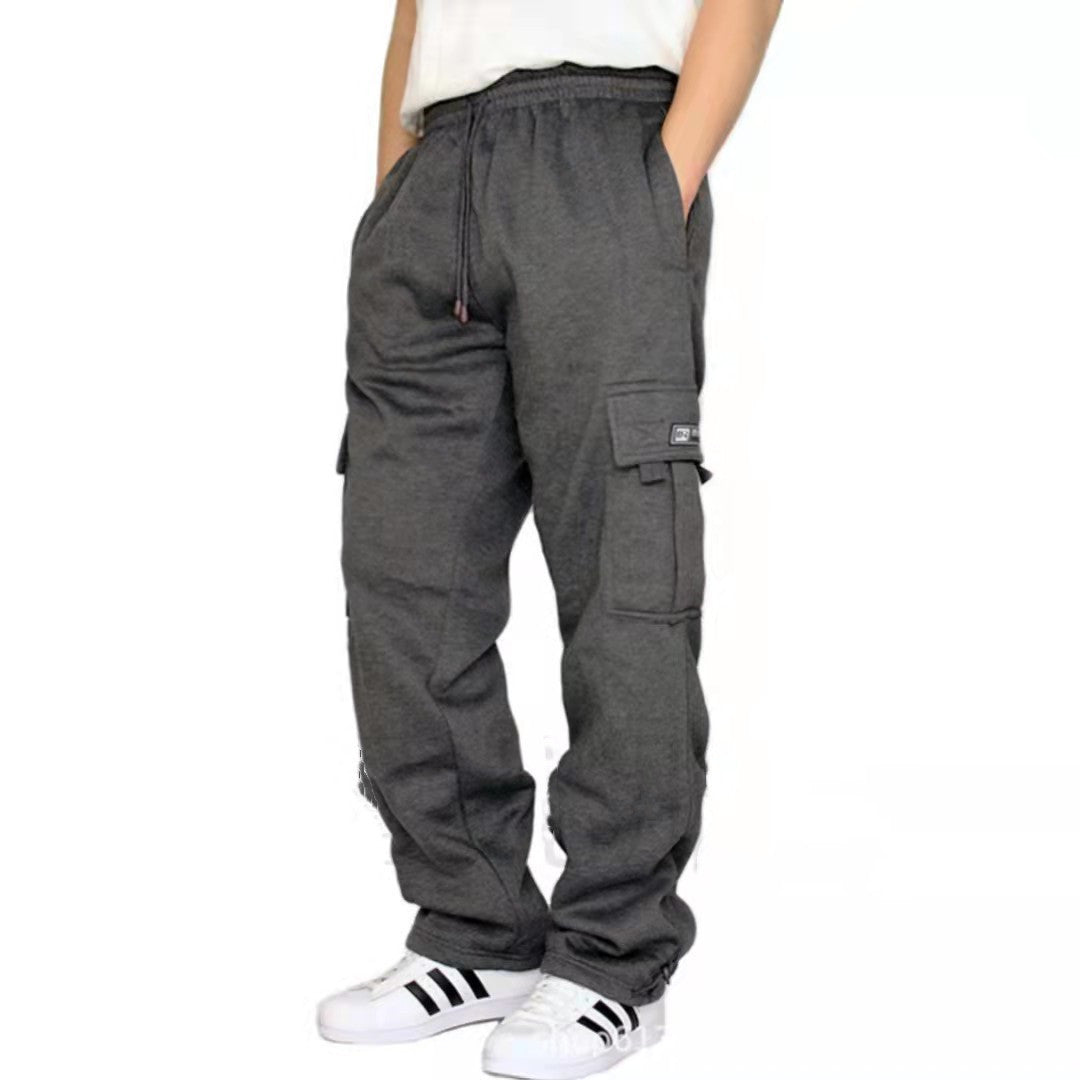 Person wearing dark gray cargo jogger pants with elastic waistband and white Adidas sneakers