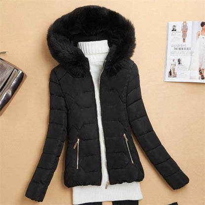 Black puffer jacket with fur hood over white turtleneck sweater on beige background