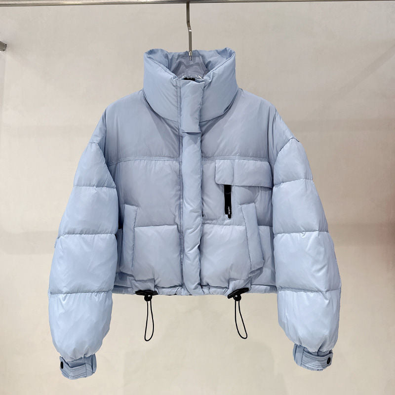 Light blue cropped puffer jacket with high collar, pockets, and adjustable drawstrings on hanger