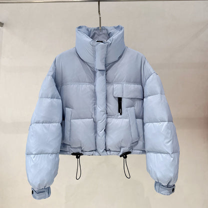 Light blue cropped puffer jacket with high collar, pockets, and adjustable drawstrings on hanger