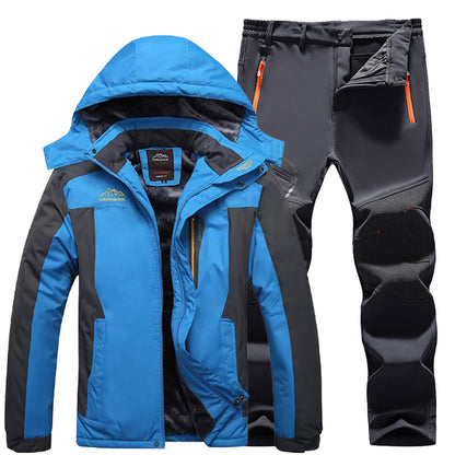 Blue and black outdoor winter jacket with hood and grey insulated hiking pants with orange zipper