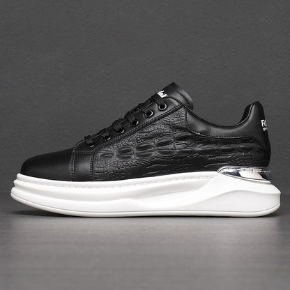 Black textured leather sneaker with white thick sole and metallic silver heel detail on gray background