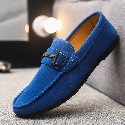 Blue suede men's loafer with metal buckle detail, cushioned sole, displayed on carpeted floor