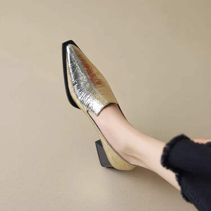 Women's metallic gold low block heel shoes with pointed toe worn with black pants