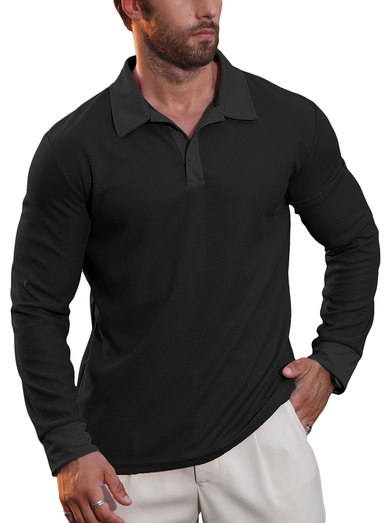Man wearing black long-sleeve textured polo shirt and light beige pants with rings on fingers
