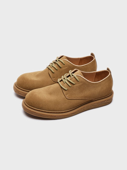 Pair of tan suede casual lace-up shoes with textured brown soles on white background