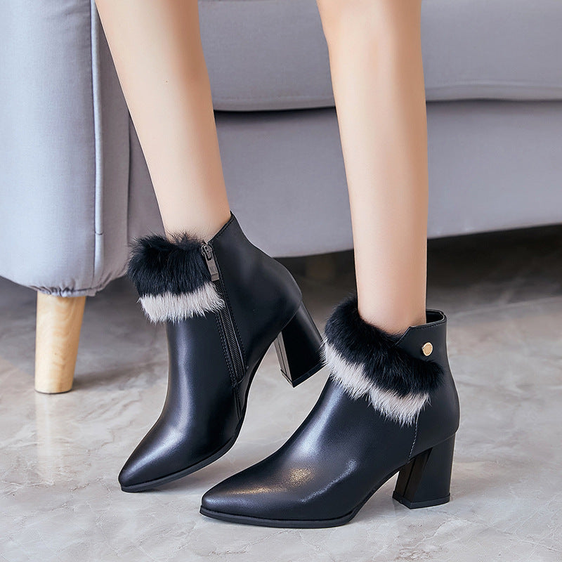 Black leather ankle boots with block heels and black-and-white faux fur trim on tiled floor