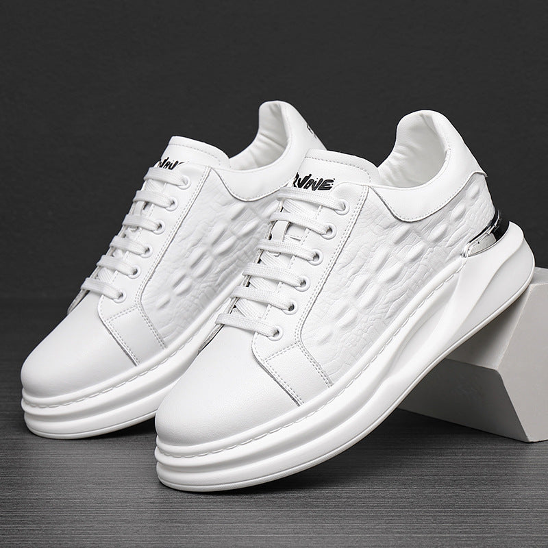 White leather sneakers with textured sides, thick soles, lace-up design, and silver heel accents on a dark surface
