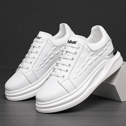 White leather sneakers with textured sides, thick soles, lace-up design, and silver heel accents on a dark surface