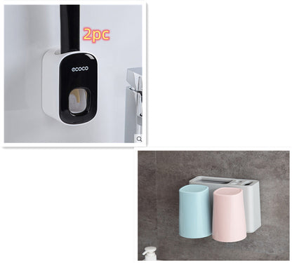 Wall-mounted black and white soap dispenser and pastel blue and pink toothbrush holders on a bathroom wall