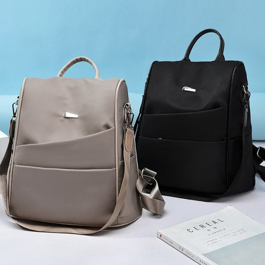 Two stylish backpacks in beige and black with front pockets and shoulder straps on a light blue background