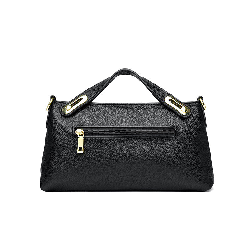 Black textured leather handbag with gold zipper and hardware, featuring a single top handle