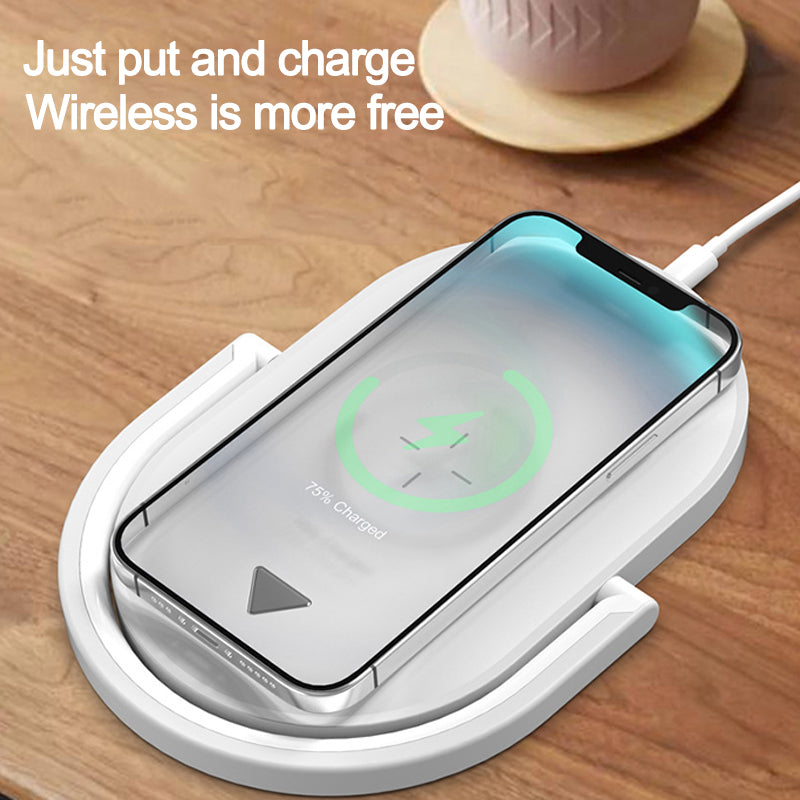 Smartphone wirelessly charging on white wireless charger pad on wooden surface