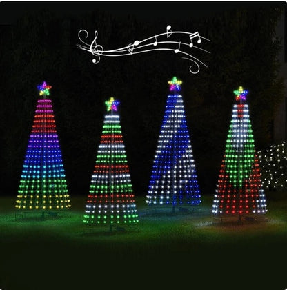 Four colorful LED Christmas tree lights in red, green, blue, and white with glowing star toppers on green grass