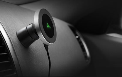 Magnetic wireless car charger mount with green LED light attached to car dashboard near air vent