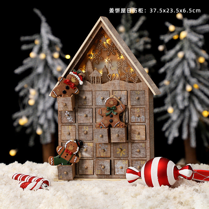 Wooden Christmas advent calendar shaped like a house with gingerbread decorations and glowing lights, snowy background