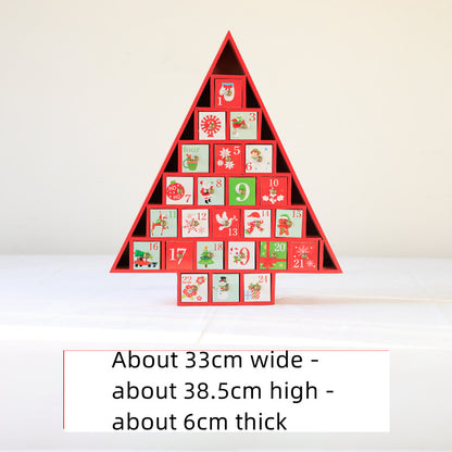 Wooden Christmas tree-shaped advent calendar with numbered festive drawers on white surface