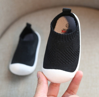 black toddler slip-on shoes with white soft soles and breathable knit fabric