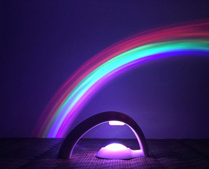 LED rainbow projector night light casting colorful arch on wall in dark room