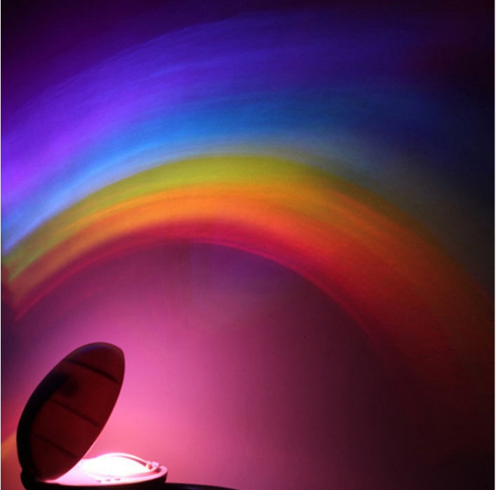 Romantic LED rainbow projector night light casting colorful arc on wall in dark room