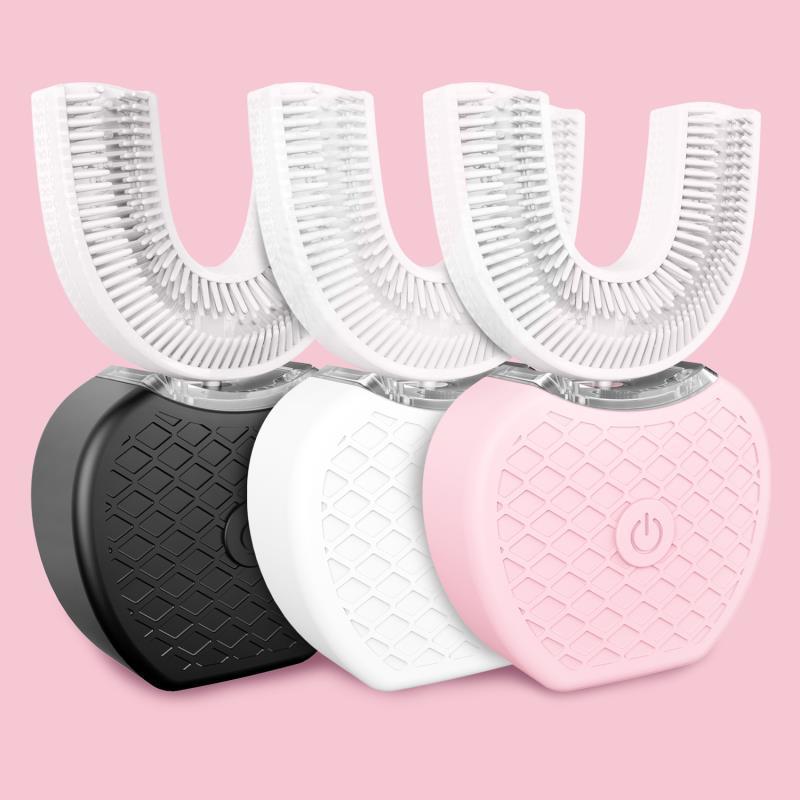 Three automatic U-shaped electric toothbrushes in black, white, and pink on a pink background