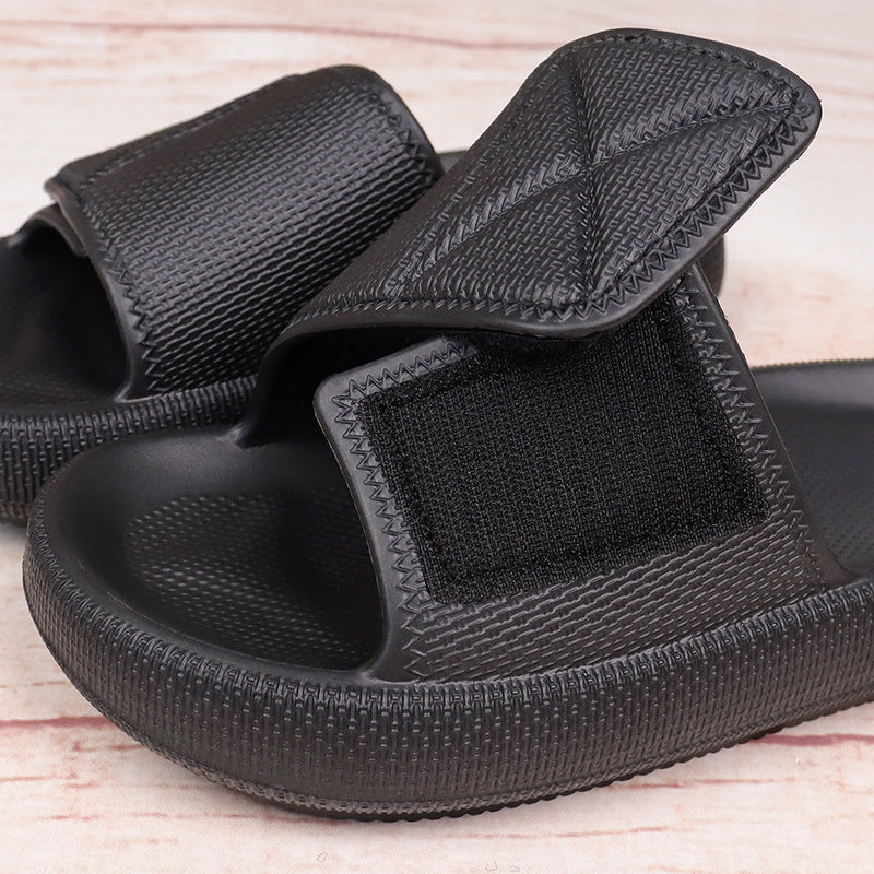 Black lightweight EVA platform slippers with adjustable straps and textured cushioning soles on wooden surface