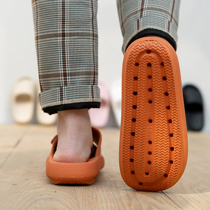 Person wearing orange EVA platform slippers with textured sole and plaid pants on wooden floor
