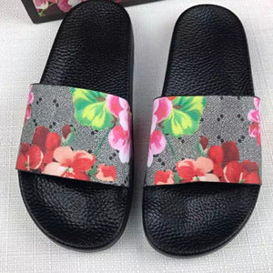 Black floral women's PVC slide sandals with pink and red flower prints on straps