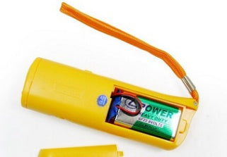 Yellow ultrasonic dog repeller with LED flashlight, open to show battery inside and orange wrist strap