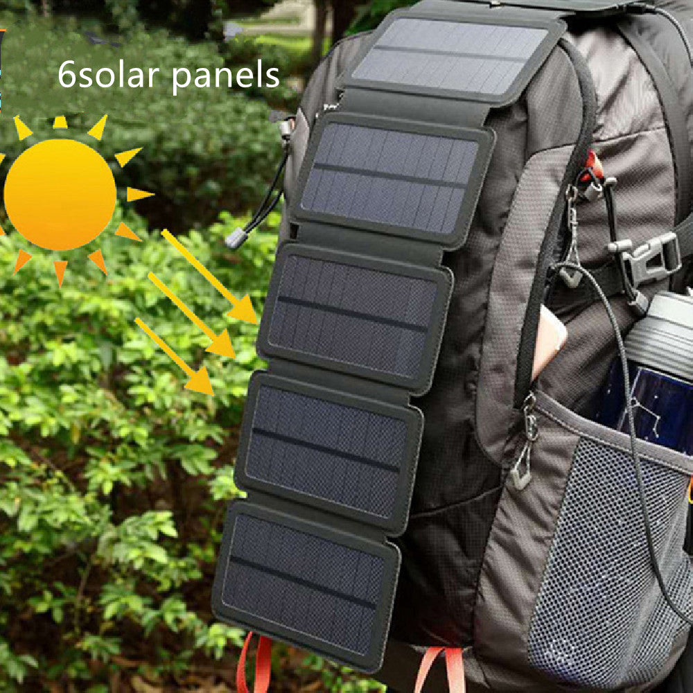 Six-panel portable solar charger attached to black hiking backpack outdoors