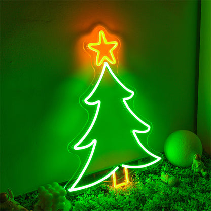 Green neon Christmas tree sign with an orange star on top, indoor decorative display