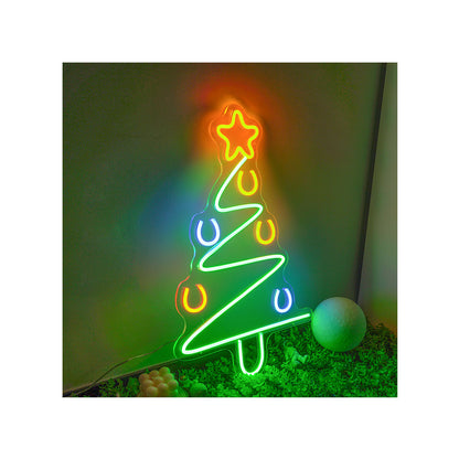 Colorful neon Christmas tree sign with star topper, horseshoe decorations, glowing indoors on green background