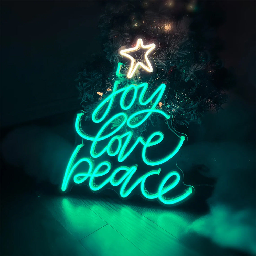 Neon Christmas tree sign with glowing star and words joy love peace in teal and white lights