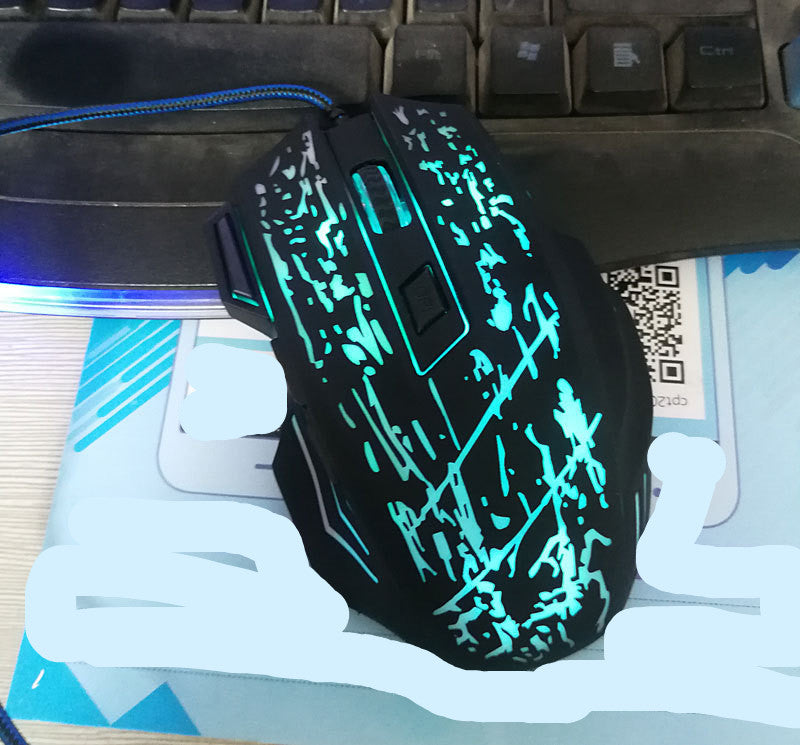 black USB gaming mouse with blue LED butterfly pattern and braided cable on keyboard