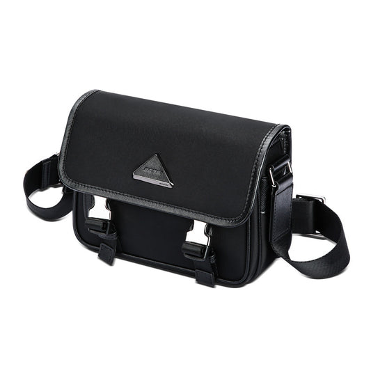 Black nylon messenger bag with adjustable shoulder strap and silver triangle logo on front flap