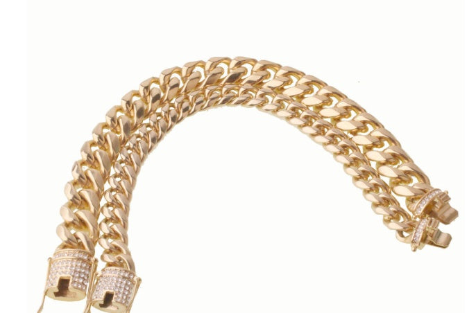 Chunky gold Cuban link chain necklace with diamond-studded clasp on white background