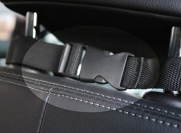 Close-up of black adjustable strap with plastic buckle attached to car seat headrest, part of waterproof dog car seat cover