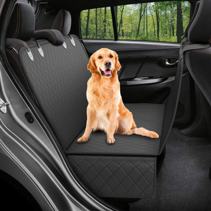 Golden retriever sitting on black quilted waterproof dog car seat cover in backseat of car