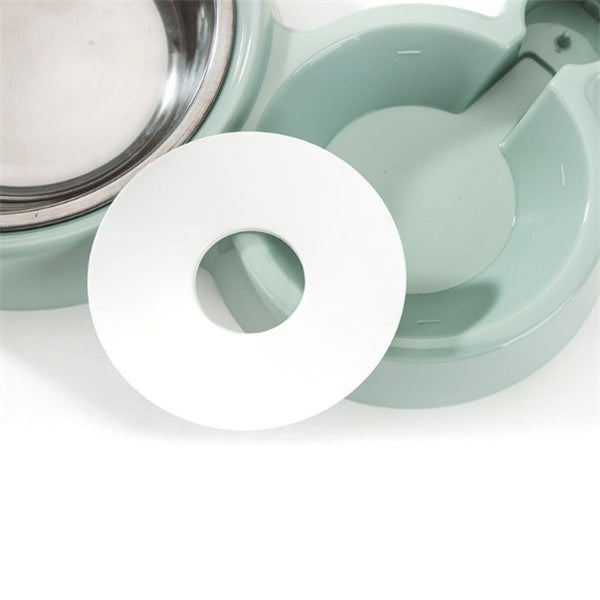 Close-up of a mint green automatic dog bowl with a stainless steel water dispenser and round white refill ball