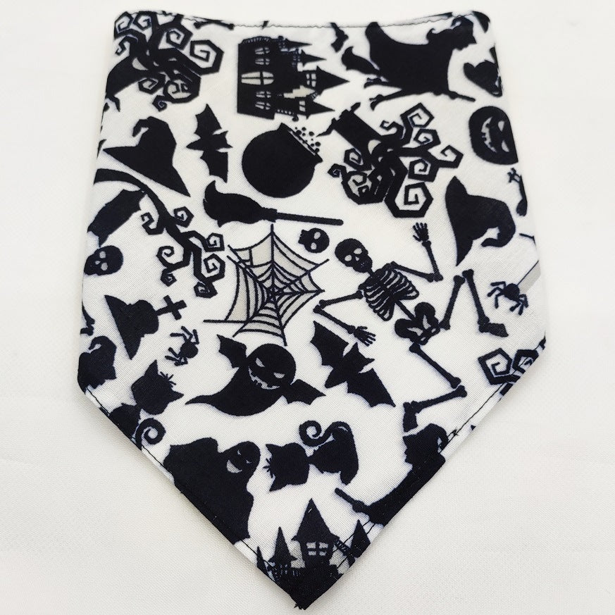 Black and white Halloween dog bandana with ghosts, skeletons, bats, witches, spider webs, and haunted houses