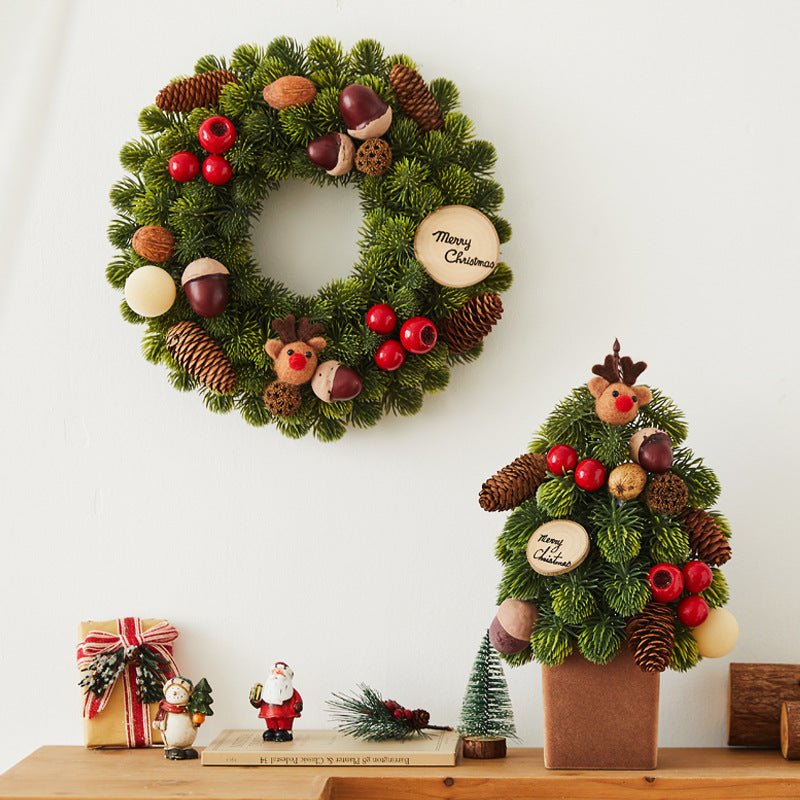 Festive Christmas wreath and miniature decorated tree with pinecones, red berries, nuts, and reindeer accents